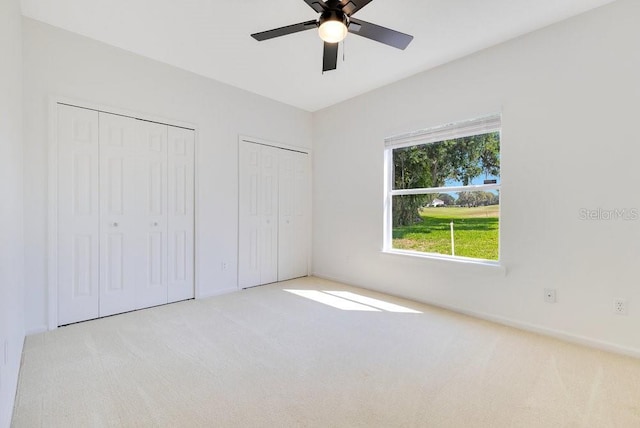 5913 Masters Blvd, Orlando, FL 32819 - unfurnished bedroom featuring two closets, carpet flooring, a ceiling fan, and baseboards