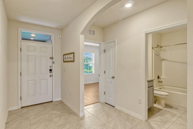 868 Brooklet Dr, Davenport, FL 33837 - entryway with arched walkways, light tile patterned flooring, and baseboards