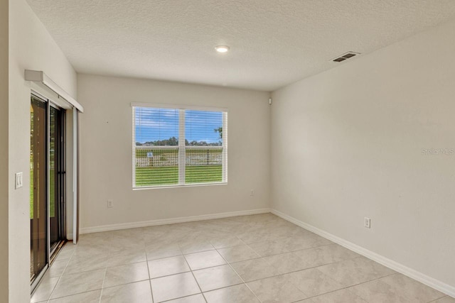 868 Brooklet Dr, Davenport, FL 33837 - unfurnished bedroom with a textured ceiling, light tile patterned floors, and baseboards