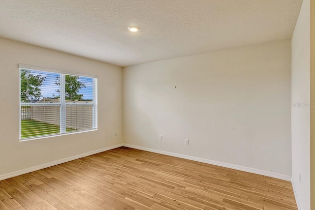 868 Brooklet Dr, Davenport, FL 33837 - empty room featuring baseboards, light wood-style floors, and a textured ceiling