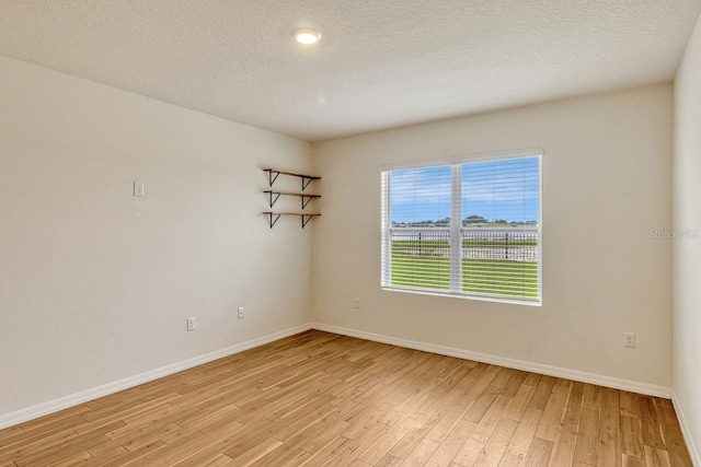 868 Brooklet Dr, Davenport, FL 33837 - empty room with light wood-style floors, baseboards, and a textured ceiling