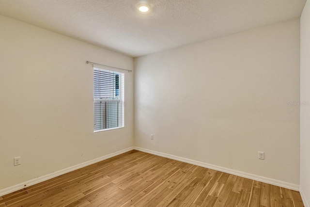868 Brooklet Dr, Davenport, FL 33837 - empty room with baseboards, light wood-style flooring, and a textured ceiling