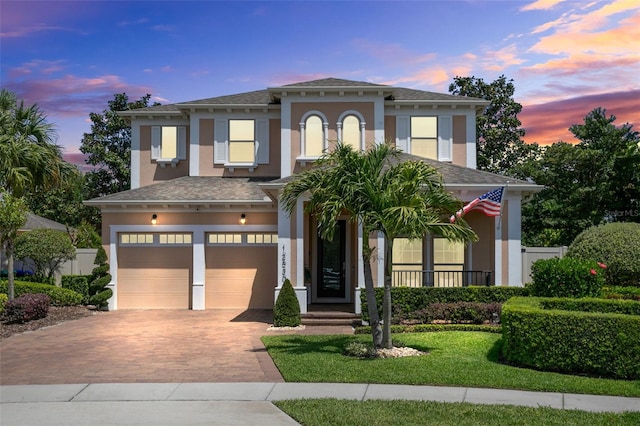 12530 Climbing Vine Ct, Windermere, FL 34786 - view of front of property featuring an attached garage, decorative driveway, stucco siding, roof with shingles, and a lawn