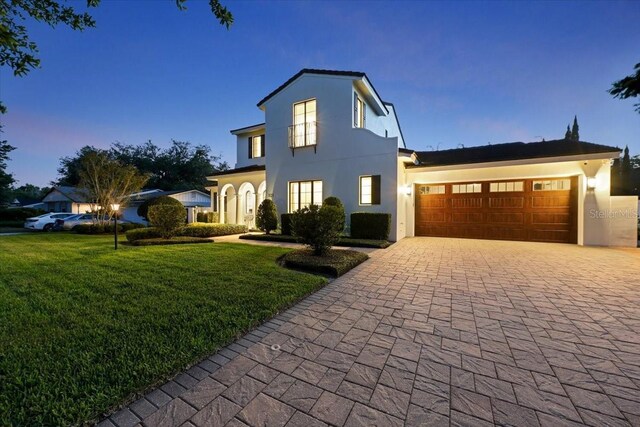 521 S Phelps Ave, Winter Park, FL 32789 - view of front facade with decorative driveway, an attached garage, a front yard, and stucco siding
