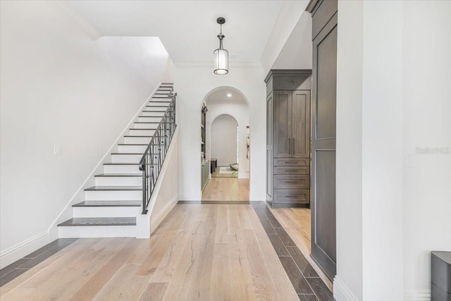 521 S Phelps Ave, Winter Park, FL 32789 - entrance foyer featuring arched walkways, wood finished floors, stairs, and ornamental molding
