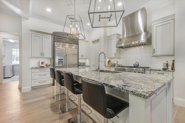 521 S Phelps Ave, Winter Park, FL 32789 - kitchen with wall chimney range hood, a sink, light stone countertops, tasteful backsplash, and recessed lighting
