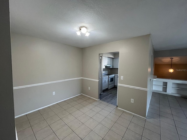 4596 Pheasant Run Dr Unit C, Orlando, FL 32808 - empty room featuring light tile patterned flooring, baseboards, and a textured ceiling