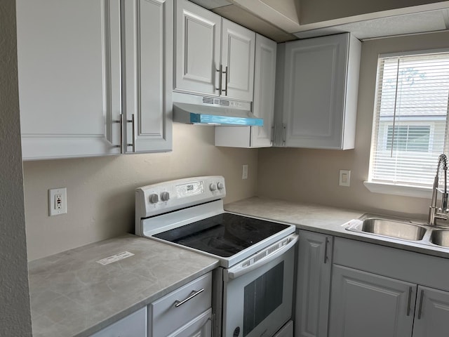 4596 Pheasant Run Dr Unit C, Orlando, FL 32808 - kitchen with white electric range, under cabinet range hood, a sink, and light countertops