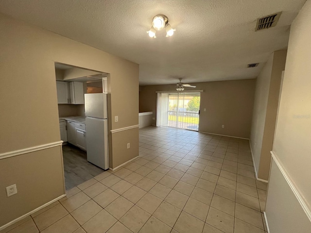 4596 Pheasant Run Dr Unit C, Orlando, FL 32808 - spare room with light tile patterned flooring, a ceiling fan, a textured ceiling, and baseboards