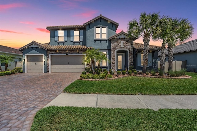 29043 Picana Ln, Wesley Chapel, FL 33543 - mediterranean / spanish house with stucco siding, stone siding, a tile roof, driveway, and a front yard