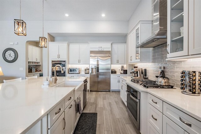29043 Picana Ln, Wesley Chapel, FL 33543 - kitchen with appliances with stainless steel finishes, wall chimney exhaust hood, light countertops, white cabinetry, and recessed lighting