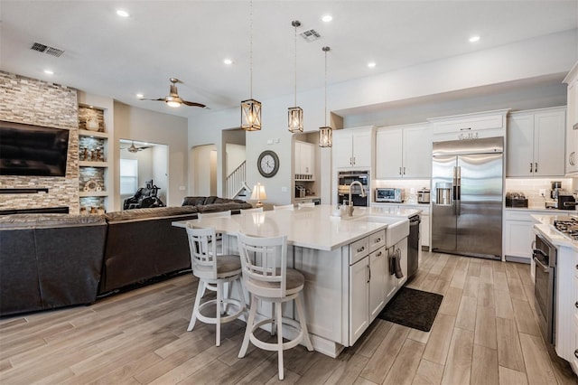29043 Picana Ln, Wesley Chapel, FL 33543 - kitchen with appliances with stainless steel finishes, a ceiling fan, open floor plan, light wood finished floors, and recessed lighting