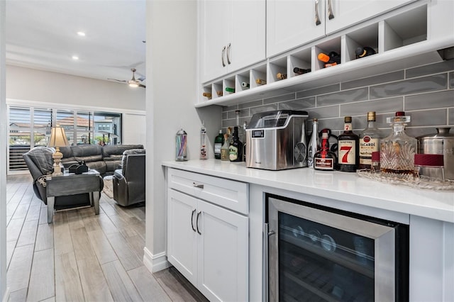 29043 Picana Ln, Wesley Chapel, FL 33543 - indoor dry bar with beverage cooler, decorative backsplash, ceiling fan, recessed lighting, and light wood finished floors