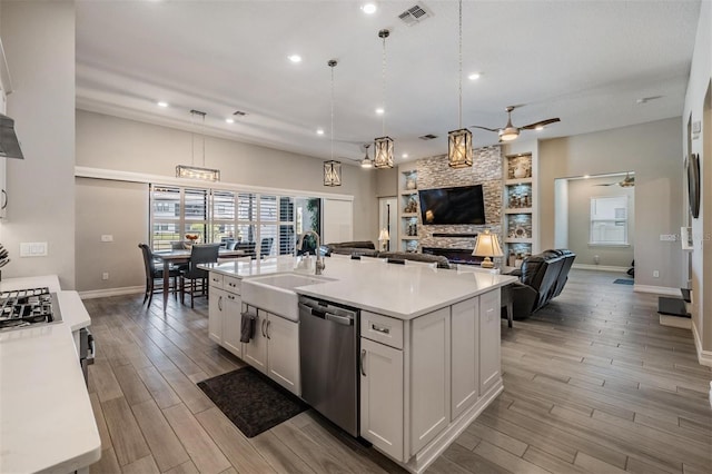 29043 Picana Ln, Wesley Chapel, FL 33543 - kitchen with stainless steel dishwasher, a sink, light wood-style flooring, light countertops, and baseboards