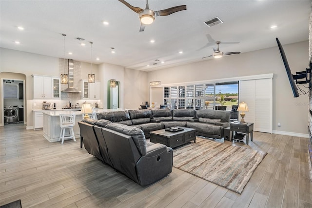 29043 Picana Ln, Wesley Chapel, FL 33543 - living room with ceiling fan, washer / dryer, light wood-style floors, recessed lighting, and arched walkways