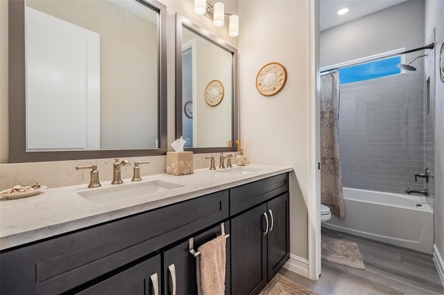 29043 Picana Ln, Wesley Chapel, FL 33543 - full bathroom featuring toilet, double vanity, shower / tub combo with curtain, wood finished floors, and baseboards