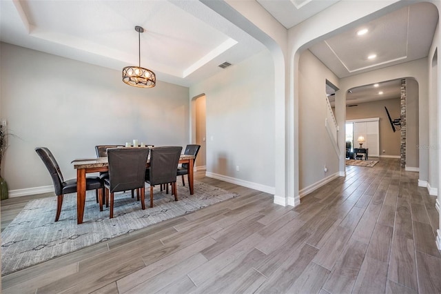 29043 Picana Ln, Wesley Chapel, FL 33543 - dining room featuring arched walkways, a tray ceiling, wood finished floors, baseboards, and recessed lighting