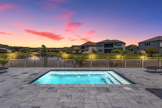 29043 Picana Ln, Wesley Chapel, FL 33543 - pool at dusk featuring a residential view, a patio, and a fenced backyard