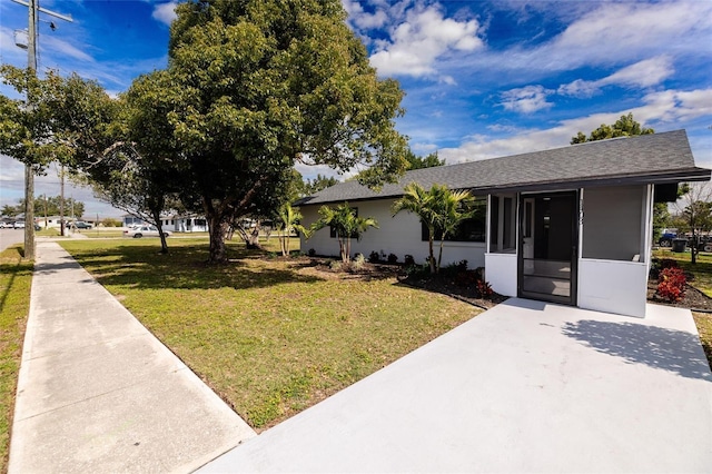 1403 Cummings Ave, Avon Park, FL 33825 - view of front facade with a front yard, a shingled roof, and a sunroom