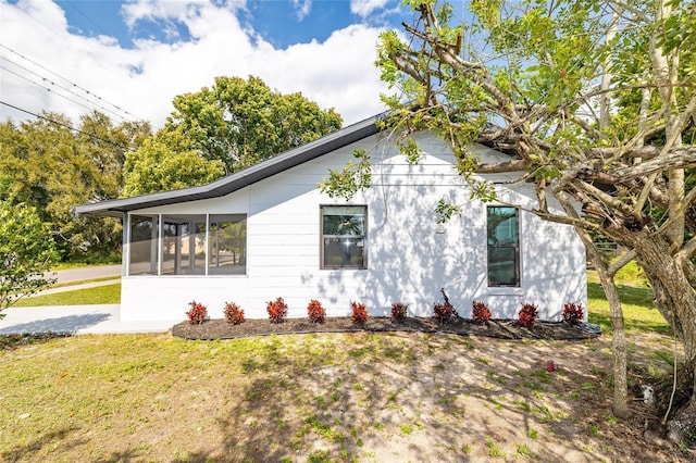 1403 Cummings Ave, Avon Park, FL 33825 - view of side of home featuring a lawn and a sunroom