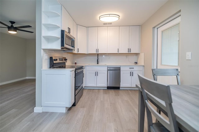 1403 Cummings Ave, Avon Park, FL 33825 - kitchen with stainless steel appliances, light countertops, light wood-type flooring, and decorative backsplash