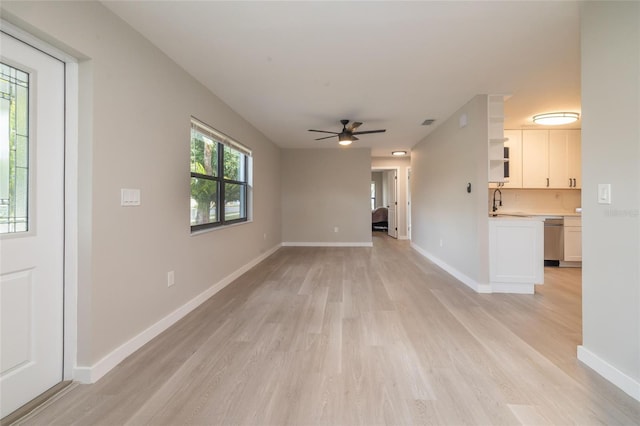1403 Cummings Ave, Avon Park, FL 33825 - unfurnished living room with light wood-style floors, ceiling fan, and baseboards