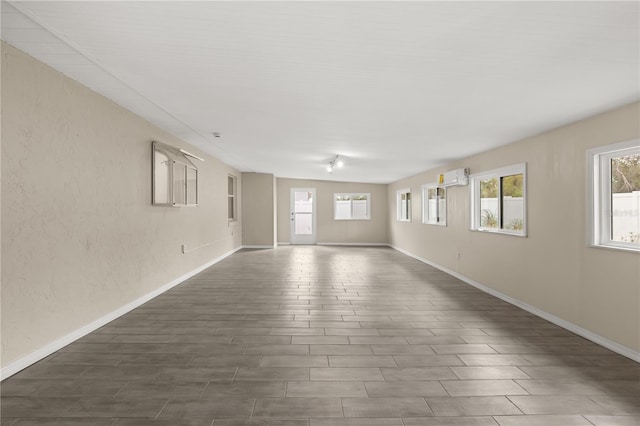15690 SW 46th Cir, Ocala, FL 34473 - spare room featuring dark wood-style flooring, an AC wall unit, and baseboards