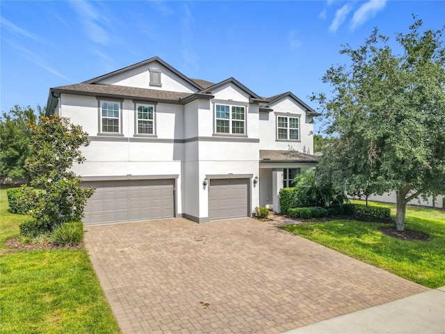 3184 Pinenut Dr, Apopka, FL 32712 - view of front of house featuring an attached garage, stucco siding, decorative driveway, and a front yard