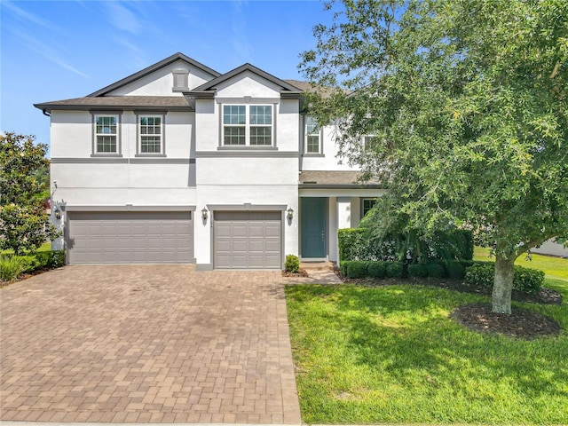 3184 Pinenut Dr, Apopka, FL 32712 - view of front of home with stucco siding, a garage, decorative driveway, and a front yard