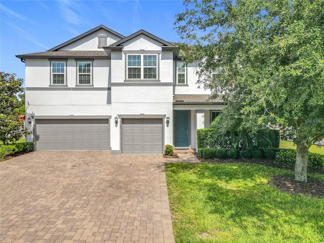3184 Pinenut Dr, Apopka, FL 32712 - view of front of home with an attached garage, stucco siding, decorative driveway, and a front yard