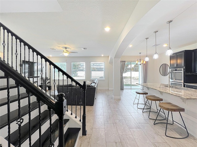 3184 Pinenut Dr, Apopka, FL 32712 - staircase featuring arched walkways, a ceiling fan, and baseboards