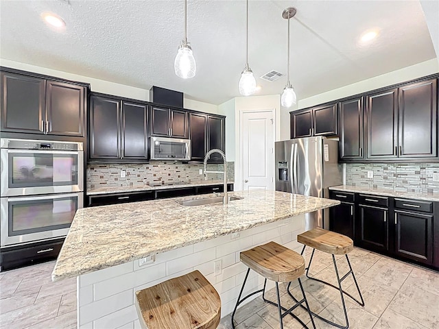 3184 Pinenut Dr, Apopka, FL 32712 - kitchen featuring a sink, appliances with stainless steel finishes, a breakfast bar, light stone countertops, and tasteful backsplash