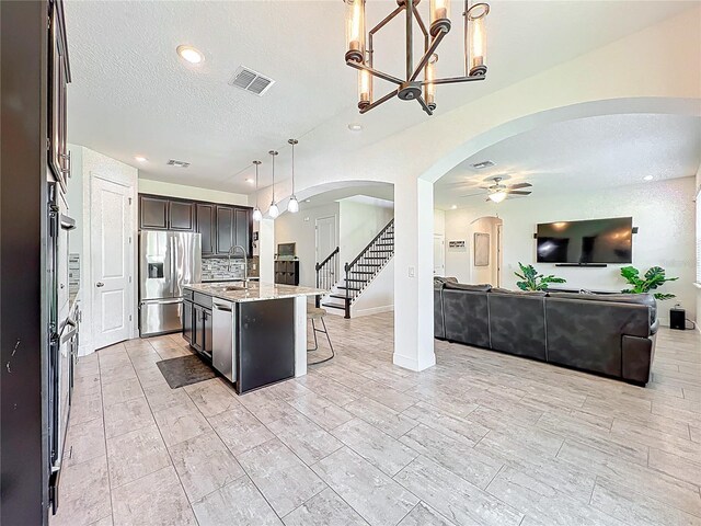 3184 Pinenut Dr, Apopka, FL 32712 - kitchen featuring appliances with stainless steel finishes, arched walkways, open floor plan, a sink, and ceiling fan