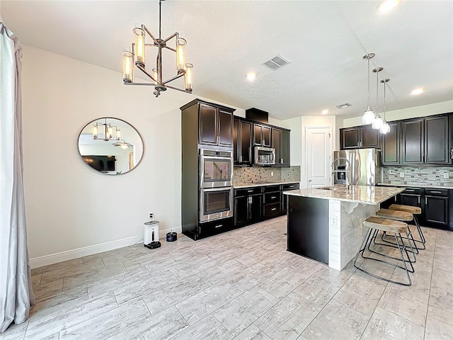 3184 Pinenut Dr, Apopka, FL 32712 - kitchen featuring a chandelier, decorative backsplash, appliances with stainless steel finishes, light stone countertops, and a kitchen bar