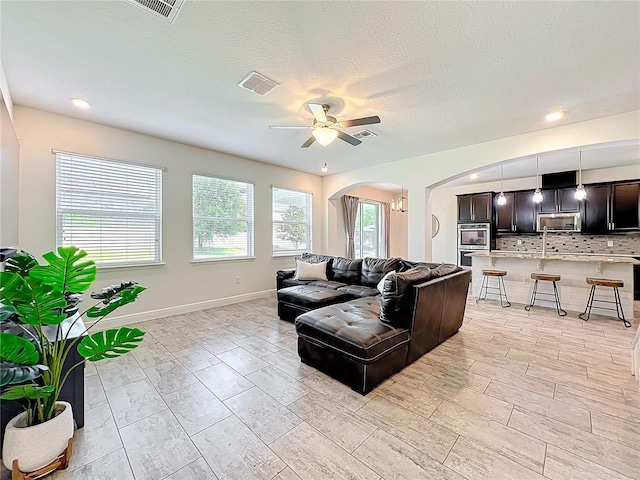 3184 Pinenut Dr, Apopka, FL 32712 - living area with arched walkways, ceiling fan, recessed lighting, and baseboards