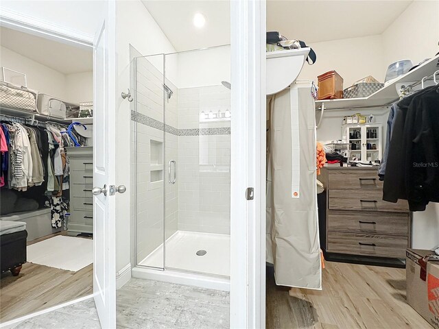 3184 Pinenut Dr, Apopka, FL 32712 - bathroom with a walk in closet, wood finished floors, and a stall shower