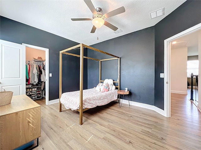 3184 Pinenut Dr, Apopka, FL 32712 - bedroom with light wood-type flooring, baseboards, a textured ceiling, and a ceiling fan