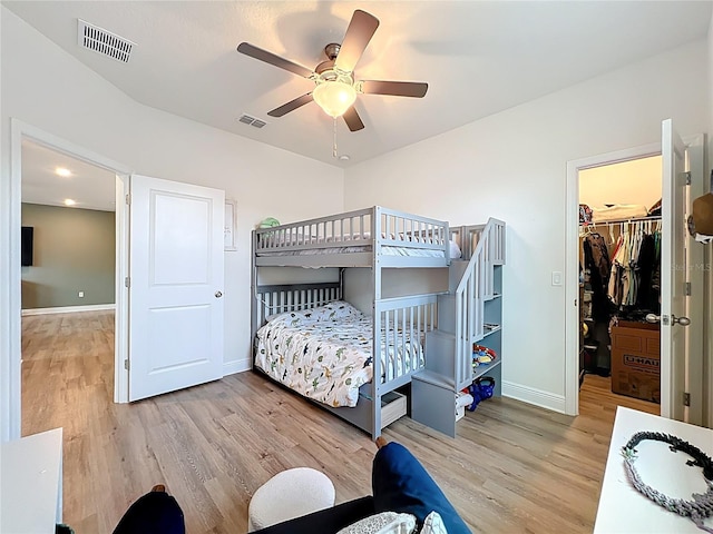 3184 Pinenut Dr, Apopka, FL 32712 - bedroom featuring wood finished floors, a spacious closet, baseboards, and ceiling fan