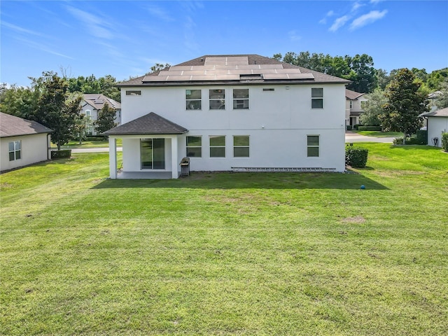 3184 Pinenut Dr, Apopka, FL 32712 - rear view of house with roof mounted solar panels, a yard, stucco siding, and a shingled roof