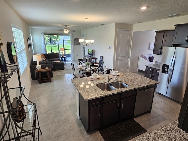 3371 Yellowtop Loop, Clermont, FL 34714 - kitchen with appliances with stainless steel finishes, a sink, an island with sink, light stone countertops, and ceiling fan