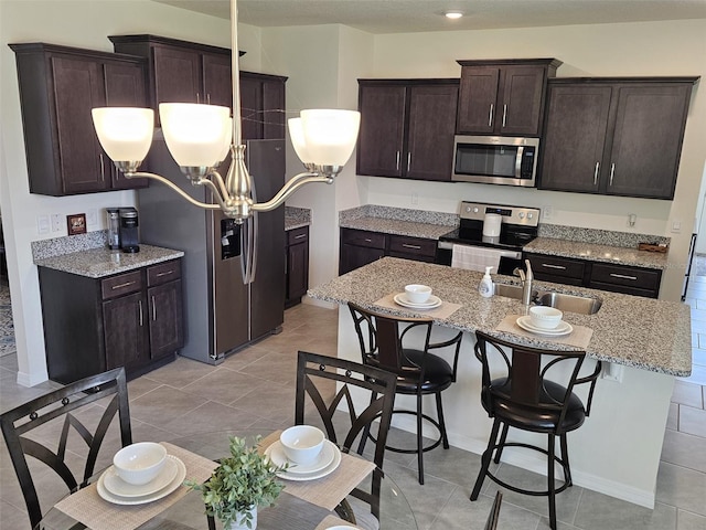 3371 Yellowtop Loop, Clermont, FL 34714 - kitchen featuring stainless steel appliances, a sink, a chandelier, dark brown cabinets, and a kitchen breakfast bar