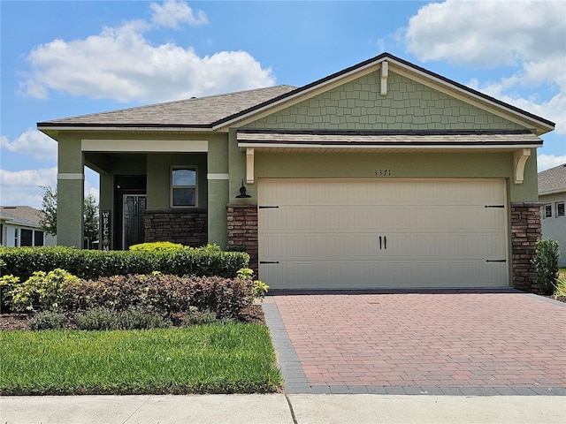 3371 Yellowtop Loop, Clermont, FL 34714 - craftsman inspired home featuring stone siding, a garage, decorative driveway, stucco siding, and a shingled roof