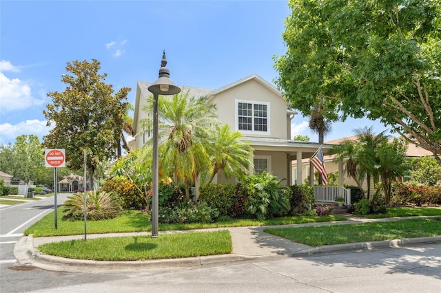 7003 Cupseed Ln, Harmony, FL 34773 - view of front facade with stucco siding, a porch, and a front lawn