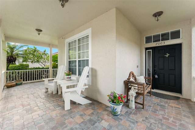 7003 Cupseed Ln, Harmony, FL 34773 - doorway to property with a porch and stucco siding