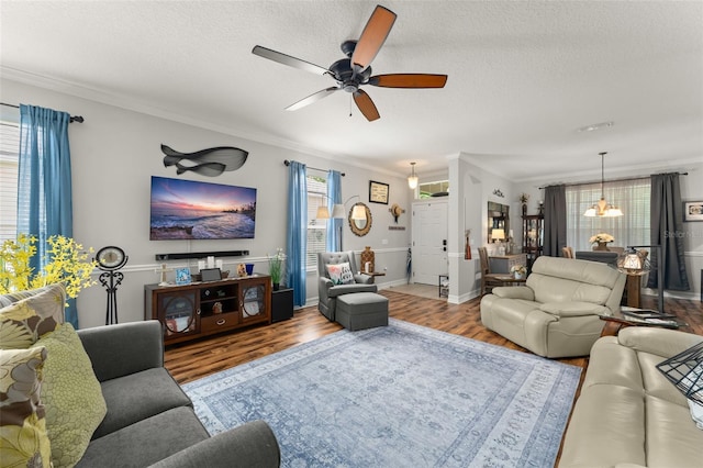 7003 Cupseed Ln, Harmony, FL 34773 - living area with ceiling fan, wood finished floors, crown molding, a textured ceiling, and baseboards