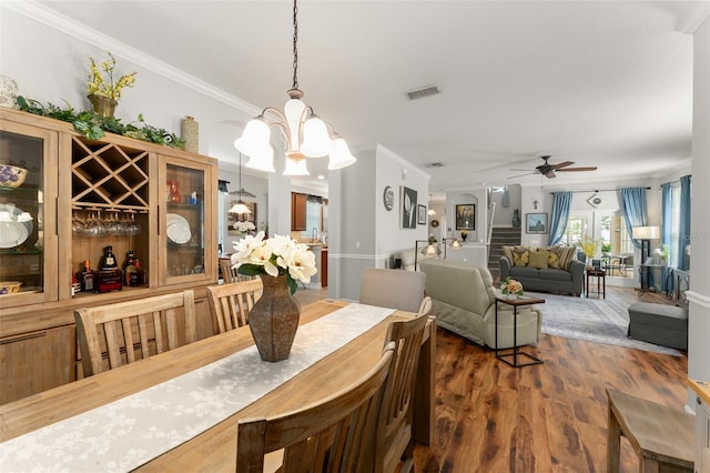7003 Cupseed Ln, Harmony, FL 34773 - dining area featuring ornamental molding, wood finished floors, a ceiling fan, and a chandelier