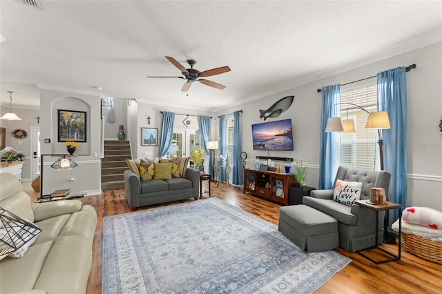 7003 Cupseed Ln, Harmony, FL 34773 - living area with stairs, crown molding, wood finished floors, a ceiling fan, and a textured ceiling