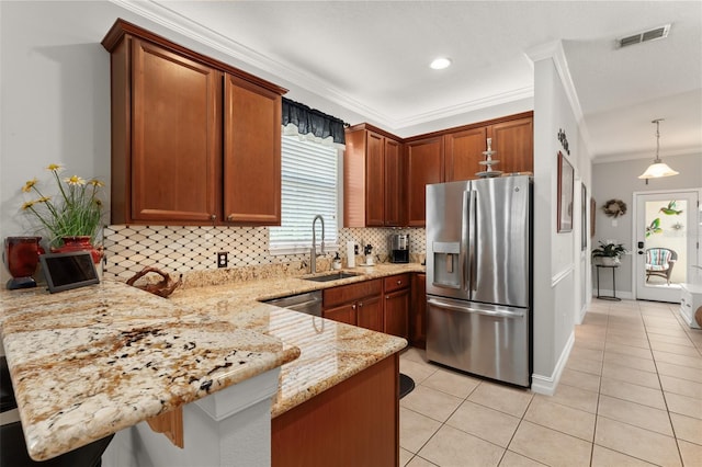 7003 Cupseed Ln, Harmony, FL 34773 - kitchen with appliances with stainless steel finishes, a peninsula, a sink, crown molding, and light tile patterned floors