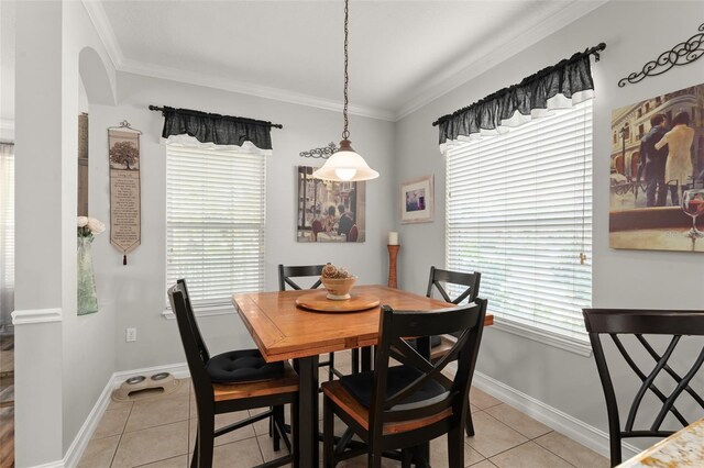7003 Cupseed Ln, Harmony, FL 34773 - dining area with light tile patterned floors, crown molding, arched walkways, and baseboards
