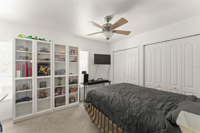 7003 Cupseed Ln, Harmony, FL 34773 - bedroom featuring two closets, a textured ceiling, light carpet, and ceiling fan